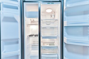 Features a spacious interior with multiple compartments, including a top freezer, main freezer, and door freezer, as well as shelves and drawers for storage.