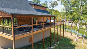 A wooden building with a balcony overlooking a body of water, featuring a sign that reads "The Porch."