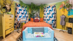 A room with a bed, a dresser, a vanity, and a chair. - Betty Blue House (Reno)