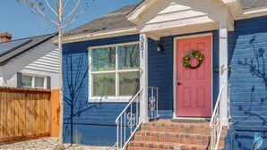 A house with a red door, a white porch, and a brick staircase. - Betty Blue House (Reno)