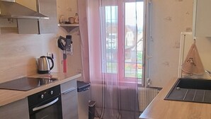 Une cuisine moderne équipée d’une cuisinière, d’un évier et d’une fenêtre avec des rideaux.