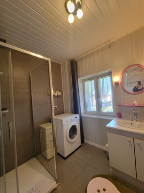Een douche, een haardroger, handdoeken, toiletpapier