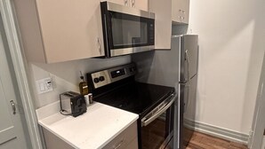 Eine kleine Küche mit Mikrowelle, Herd und Kühlschrank.