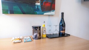 Une table avec une boîte de chips Yorkshire, une bouteille de gin Summer House, deux verres à vin et un plateau.