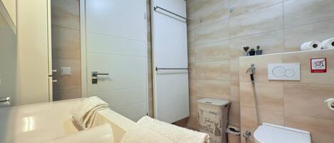 Un baño moderno con bañera, inodoro y zona de ducha.