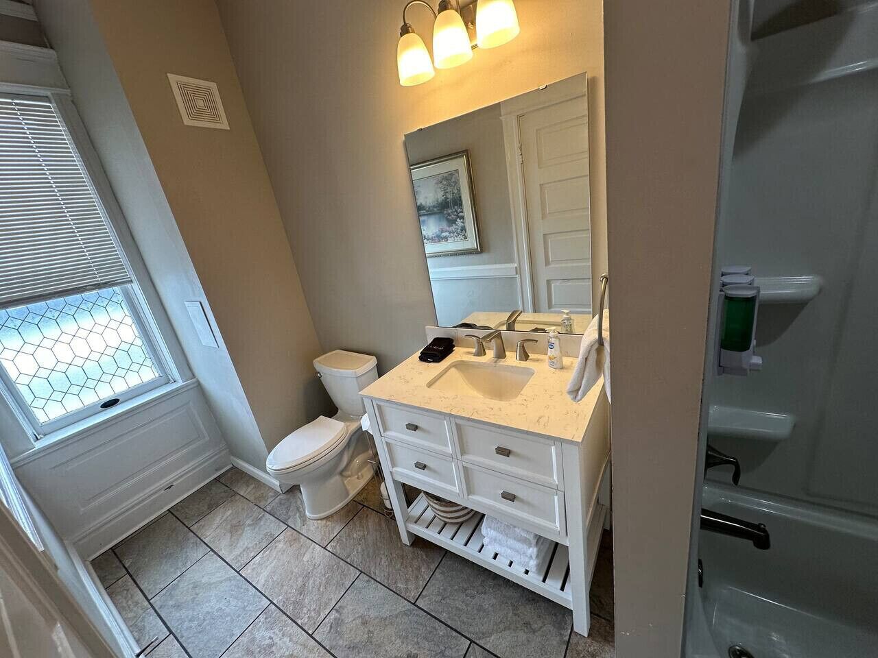 A bathroom with a toilet, sink, and vanity.