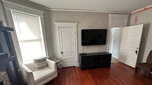 A living room with a sofa, a TV, and a black entertainment unit.