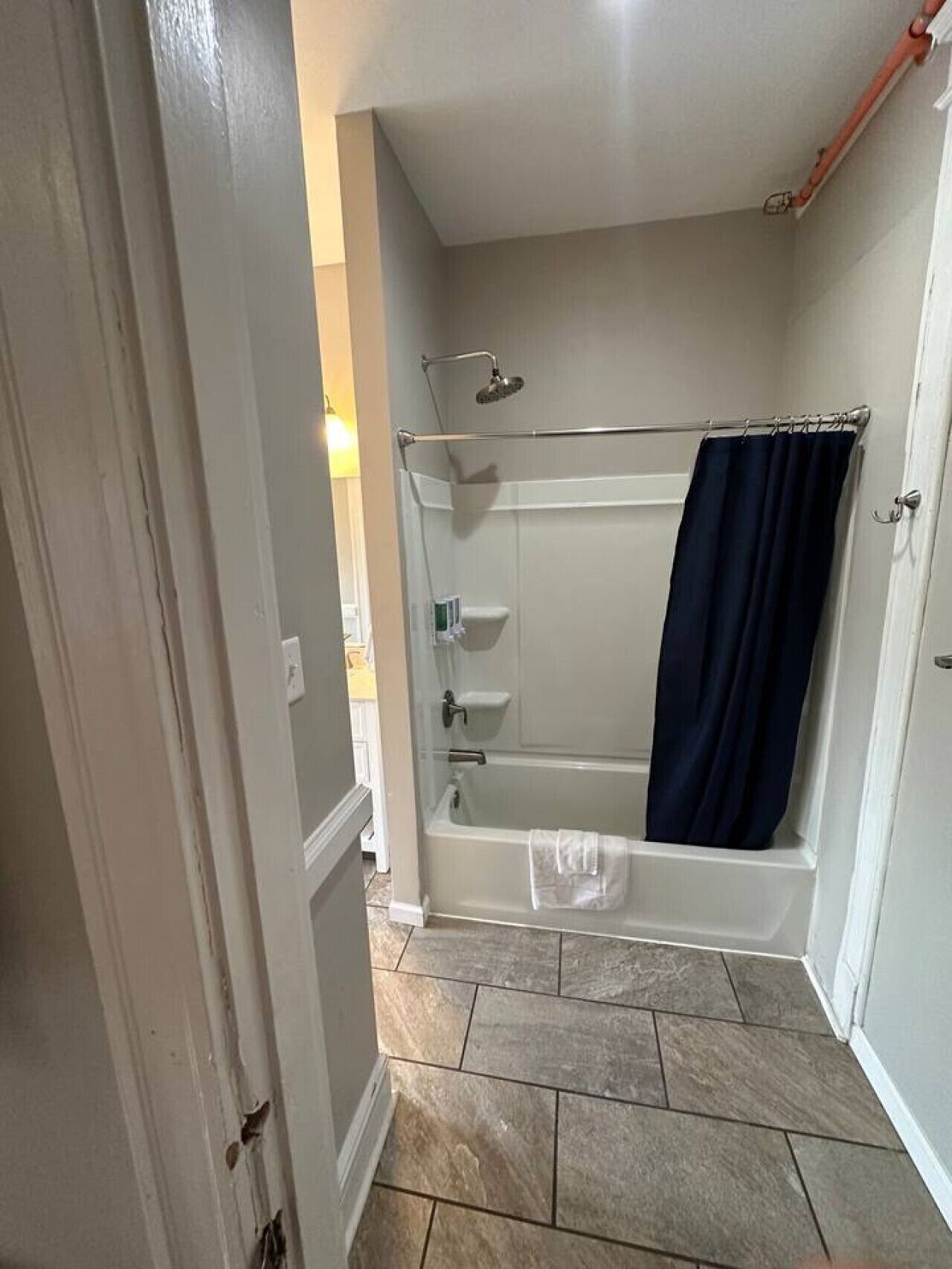 Ein Badezimmer mit Badewanne, Dusche und Handtuchhalter.