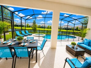 A covered outdoor area with a pool, lounge chairs, and a dining table. - 2500 Luxury 12 B.R 11.5BA 19 B.D in upscale community Pool/Game Close to Disney (Kissimmee)