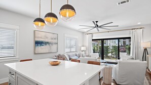 A modern kitchen with a large island, pendant lighting, and a view to the outside. - VitaSea/Private Beach/Bike2Seaside (Santa Rosa Beach)
