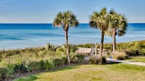 A beachfront property with palm trees, a pathway, and a building with a sloped roof. - VitaSea/Private Beach/Bike2Seaside (Santa Rosa Beach)