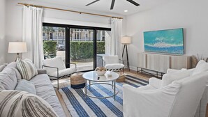 A modern living room with a sofa, armchairs, a coffee table, and a ceiling fan. - VitaSea/Private Beach/Bike2Seaside (Santa Rosa Beach)