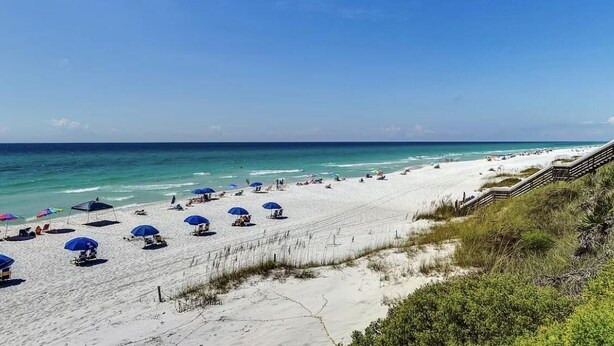 A beach with white sand, blue umbrellas, and a wooden walkway leading to the water. - VitaSea/Private Beach/Bike2Seaside (Santa Rosa Beach)