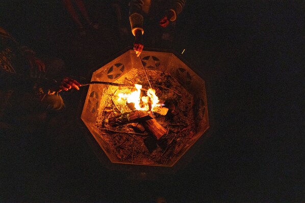 A hexagonal lantern with a fire inside, suspended by a chain.