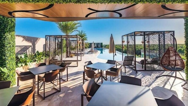Un espace extérieur aménagé avec des tables et des chaises, une piscine et une vue sur le paysage.