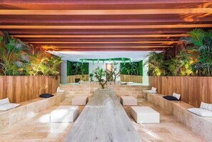 Relax in a spacious lounge area with plush seating and lush greenery.