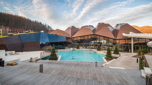 Un hôtel moderne doté d’une piscine, d’une terrasse en bois et d’une architecture originale.