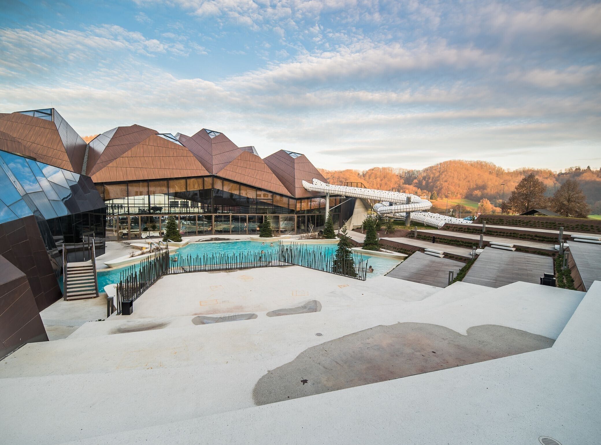 A modern building with a pool and outdoor seating area.