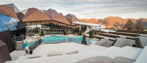 A modern building with a pool and outdoor seating area.