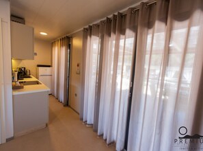 Enjoy a compact room with a kitchenette, featuring a refrigerator, coffee maker, and sink, and a comfortable bed.