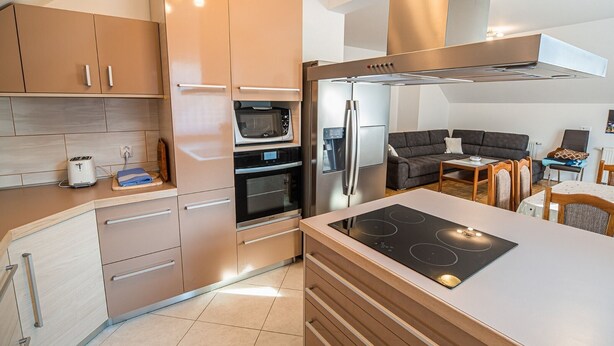 Una cocina moderna con electrodomésticos integrados, un comedor y un espacio de sala.