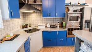 A modern kitchen with blue cabinets, a built-in stove, and a stainless steel oven.