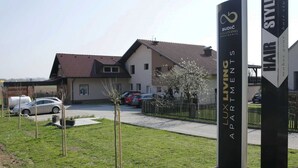 A residential building with a sign for 'BUDIC LUXURIOUS APARTMENTS'.