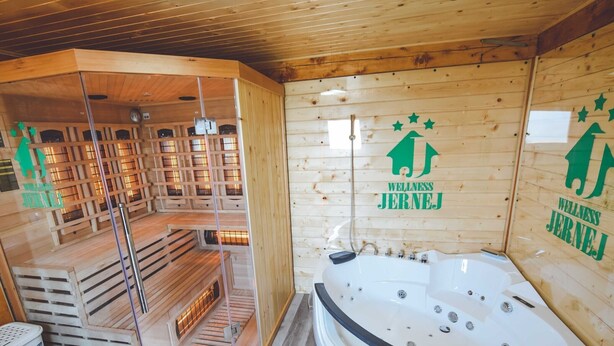Een wellnessruimte met een sauna, een massagetafel en een ruime badkuip.