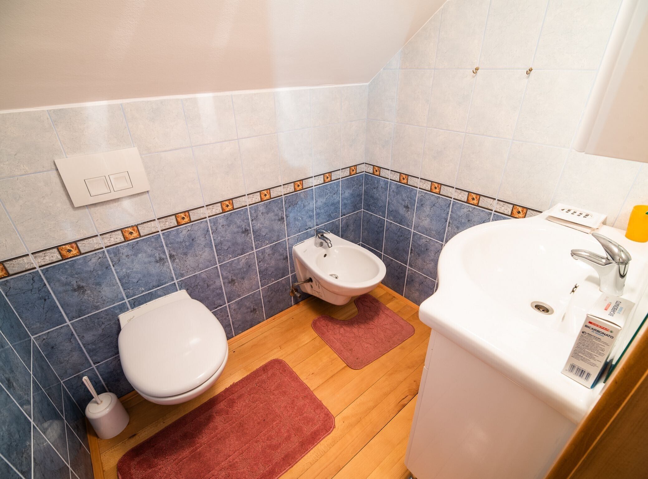 Et badeværelse med toilet, pissoir og håndvask.