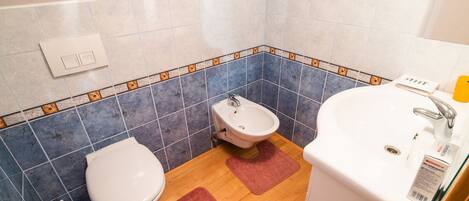 Et badeværelse med toilet, pissoir og håndvask.