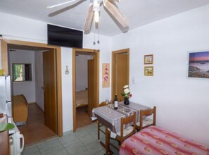 Cozy retreat with a dining table, comfortable bed, and framed artwork.