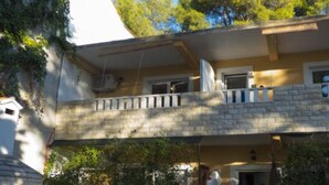 Ein zweistöckiges Gebäude mit Balkon und Steinverkleidung.