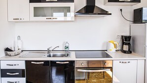 Una cocina moderna con electrodomésticos de acero inoxidable, microondas, estufa y cafetera.