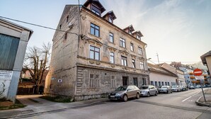 Un edificio de varios pisos con un estilo arquitectónico clásico, que destaca por una entrada imponente con una reja metálica y un letrero.