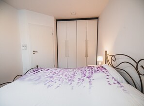 Ein Schlafzimmer mit einem Bett, einem Kleiderschrank und einer Nachttischlampe.