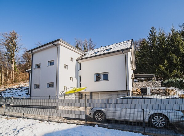 Ein zweistöckiges Gebäude mit weißer Fassade und geneigtem Dach.