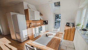 A modern kitchen with a wooden table, white cabinets, and a built-in oven.