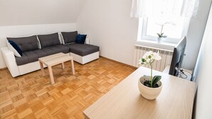 Un soggiorno moderno con un divano componibile, un tavolino in legno e un'orchidea in vaso.