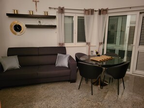 Relax in this stylish living space with a sofa, round table, and two chairs.