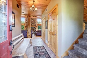 A wooden interior with a stone fireplace, a sofa, and a staircase. - Big Woods and Yellow River (Necedah)