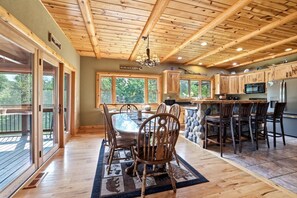 A cabin interior with a dining area, kitchen, and a stone accent wall. - Big Woods and Yellow River (Necedah)