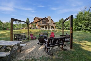 A lodge with a large wooden deck, outdoor seating, and a stone fireplace. - Big Woods and Yellow River (Necedah)