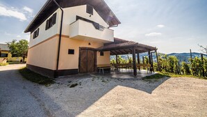 Una casa a due piani con un portico coperto e vista sulla campagna.