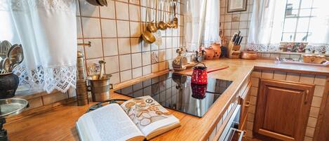 Een koelkast, een oven, een vaatwasser, kookgerei, borden en bestek