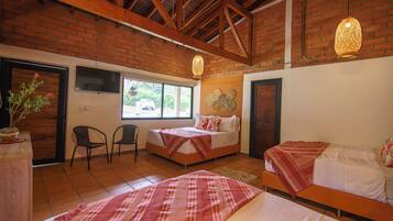 Una habitación con dos camas, televisión, ventana y una planta.
