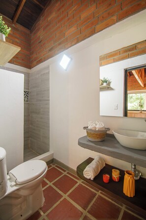 Standaard kamer, uitzicht op tuin | Badkamer | Een douche, handdoeken, zeep, shampoo