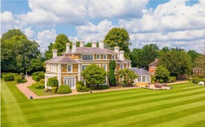 A large, two-story house with a well-maintained lawn and garden.