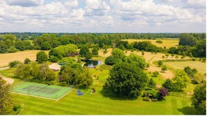 Ein Golfplatz mit Tennisplatz, Teichen und üppigem Grün.