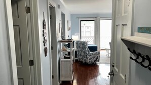 A hallway with a starfish rug, a chair, and a view to a balcony. - Beautiful 2-bedroom condo with ocean views, Wi-Fi, AC, wshr/dryr in Myrtle Beach (Myrtle Beach)