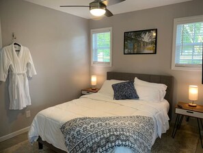 Relax in comfort with a large bed, bedside lamps, and a ceiling fan.